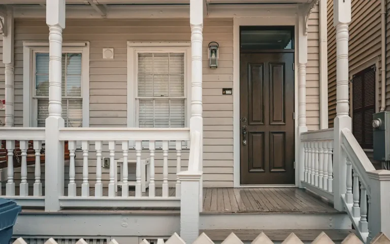 Porch and dark front door of a white house, locksmith in Auburndale, FL