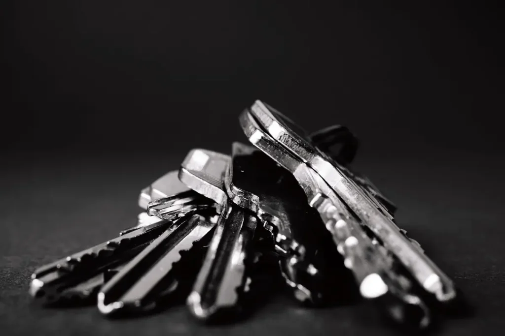 Pile of dark house keys on a black background, key cutting in Lakeland, FL